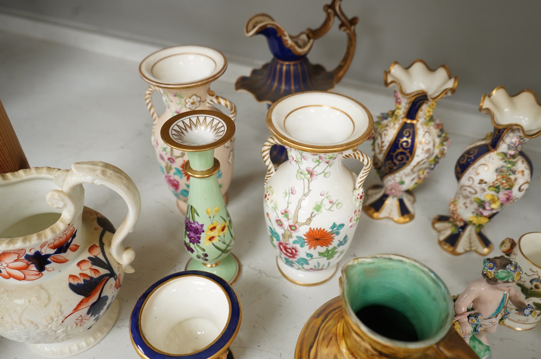 Large group of 19th/20th century English ceramics, to include a Rockingham basket, other English porcelain flower encrusted vessels, a Copeland and Garrett ewer, a Minton Sevres style beaker, a Wedgwood agate ware jug, R